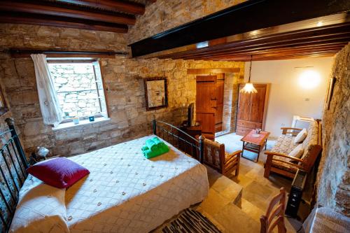 a bedroom with a large bed in a stone room at Constantias stone houses in Lofou