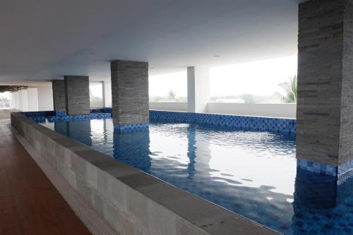 a swimming pool in a building with blue at Minimalist Studio Apartment at Poris 88 with City View By Travelio in Tangerang