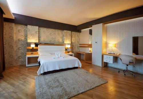 a large bedroom with a bed and a desk at Anemon Grand Adana Otel in Adana