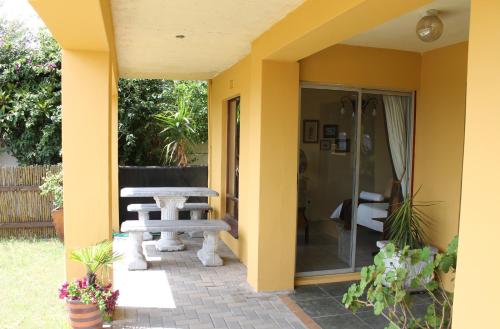 a patio with a table and a bench on a patio at Goblin's Inn in Stompneusbaai