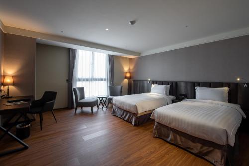 Habitación de hotel con 2 camas y escritorio en Lai Hotel en Guiren