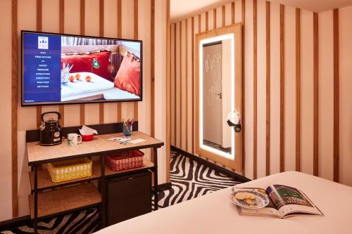 a room with a flat screen tv on a striped wall at Mama Shelter London - Shoreditch in London