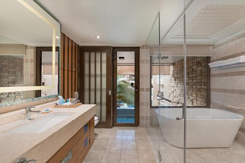uma casa de banho com uma banheira, um lavatório e um chuveiro em Henann Lagoon Resort em Boracay