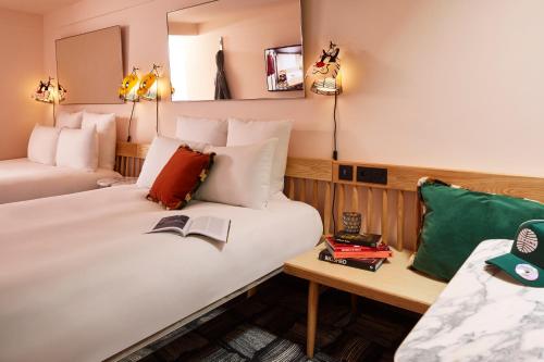 a hotel room with two beds and a table at Mama Shelter London - Shoreditch in London