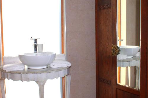a bathroom with a white sink and a mirror at Goblin's Inn in Stompneusbaai