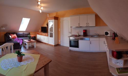 een keuken en een woonkamer met een tafel bij Ferienwohnung Wasserlilie in Kolonie