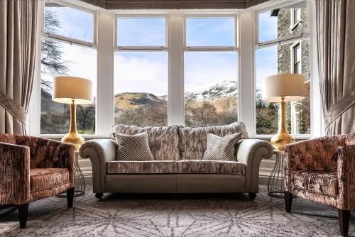 a living room with a couch and two chairs and a large window at The Inn On The Lake in Glenridding