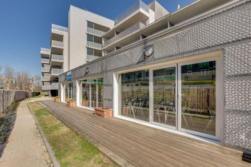 a building with large windows and a wooden deck at Résidence Azurea in Aix-les-Bains