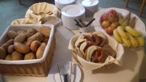 a table with baskets of bread and fruit on it at Hotel am Bad in Tübingen