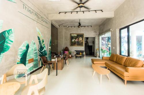 a living room with a couch and tables and chairs at Thien Phu Garden Hotel in Hanoi