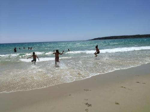 a group of people playing in the water at the beach at miCielo - Baumhäuser in Vejer de la Frontera