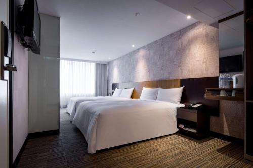 Un dormitorio con una gran cama blanca y una pared en 台北碧瑤飯店 Hotel B en Taipéi