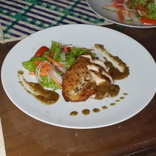 a plate of food with chicken and a salad at Pearl Cave Cabanas & Resturant in Tangalle