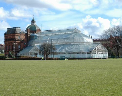 a large glass greenhouse in front of a building at The Stables - Fabulous stylish flat in Merchant City & Free Secure Parking in Glasgow