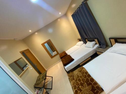 a small room with two beds and a mirror at Hôtel EDHIAFA in Al Madīnah