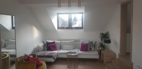 a living room with a white couch with pink pillows at Boutique-Hotel „Altes Rathaus“ in Lahnstein