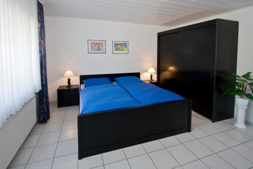 a bedroom with a large blue bed in a room at Pension Mosella , Wohnung mit Balkon und Moselblick in Sankt Aldegund