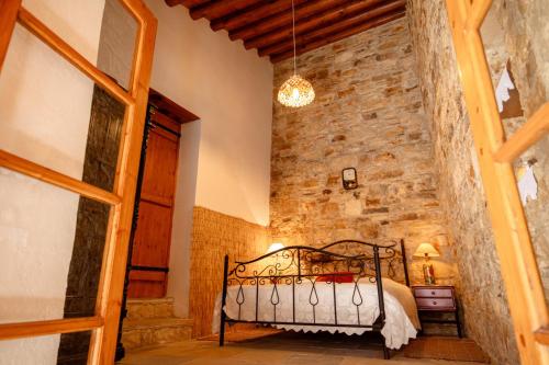 a bedroom with a bed and a stone wall at Constantias stone houses in Lofou