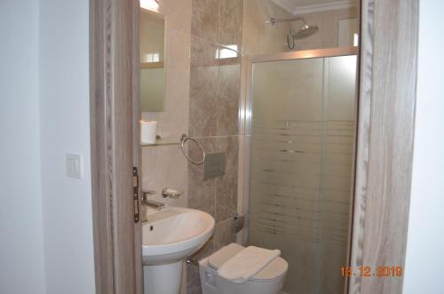 W łazience znajduje się umywalka, toaleta i prysznic. w obiekcie Hotel Uygar w mieście Fethiye