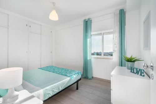 a white room with a bed and a window at APARTAMENTO COR DO MAR - Sunny, Clean and spacious apartment with sea view, in Alvor - very close walking distance to the beach and Alvor Village in Alvor