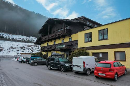 un gruppo di auto parcheggiate di fronte a un edificio di Alpenpension Haslinger a Bad Gastein