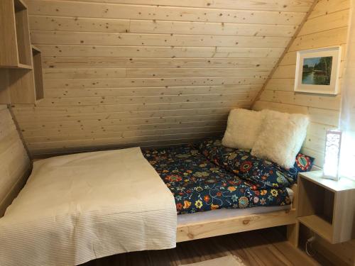 a small bedroom with a bed in a log cabin at Chaty Mazur w Wierzbie in Ruciane-Nida