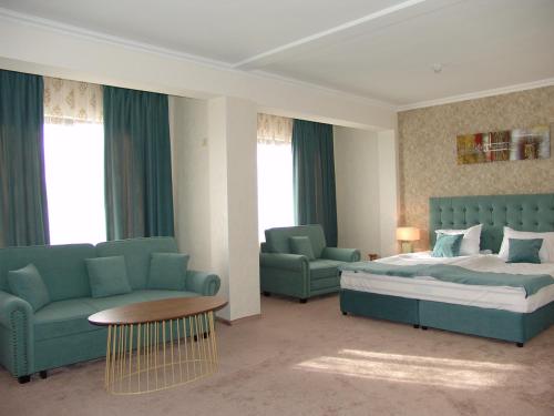 a bedroom with a bed and a couch and a table at Hotel Zheleznik in Stara Zagora