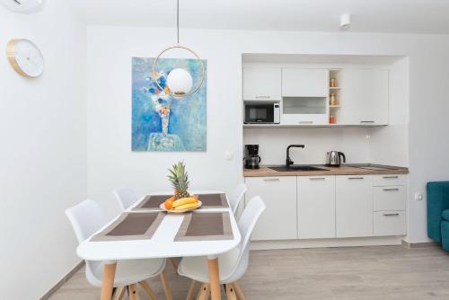 a kitchen and dining room with a white table and chairs at Sun Paradise in Podgora