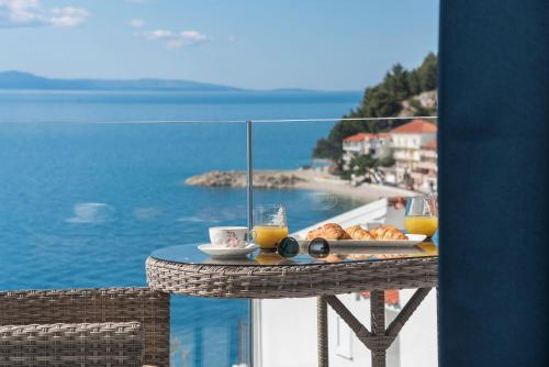 a table with a tray of food and glasses of orange juice at Sun Paradise in Podgora