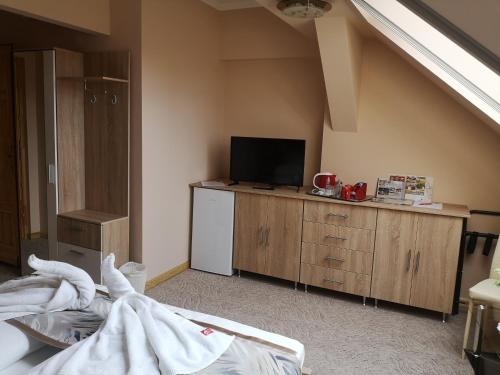 a room with a bed and a television in a room at Szent István Wellness Panzió in Makó