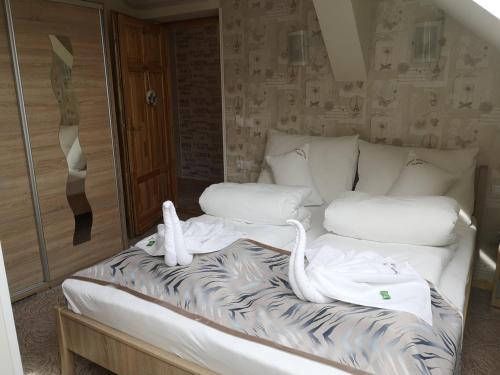 a bed with swans on it in a room at Szent István Wellness Panzió in Makó