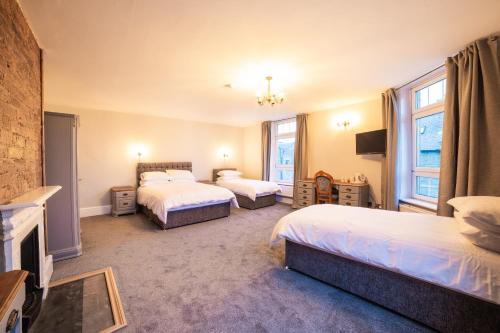 a hotel room with two beds and a fireplace at Churchill's Hotel in Wombwell