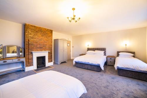 a bedroom with two beds and a fireplace at Churchill's Hotel in Wombwell