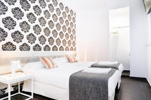una camera da letto con un divano bianco e carta da parati in bianco e nero di Valencia Luxury - Boutique Center a Valencia