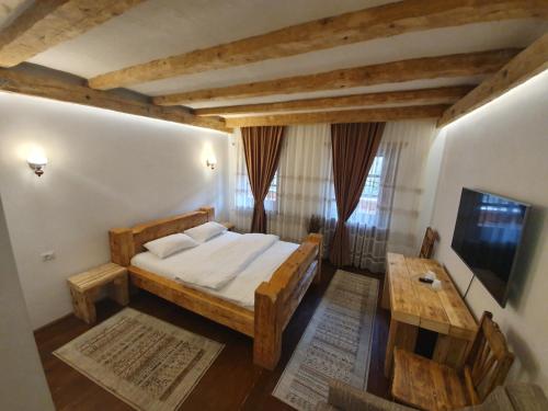 1 dormitorio con cama, mesa y TV en Păstrăvăria Alex, en Mara