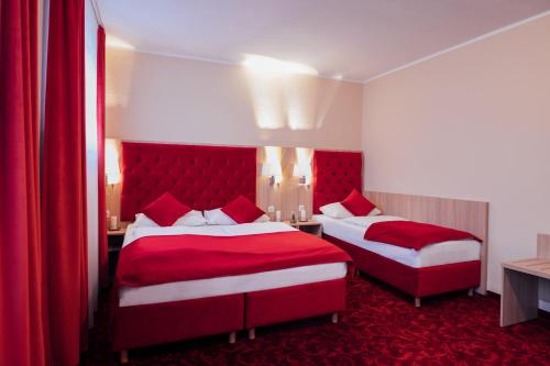 a hotel room with two beds with red covers at Hotel CULT Hamburg in Hamburg