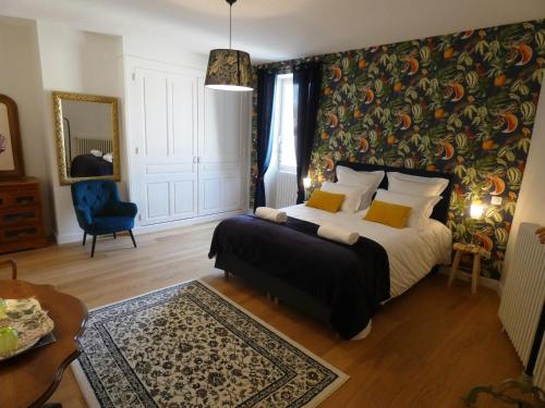 um quarto com uma cama e uma parede coberta de papel de parede floral em Le Clos De Quintaine Chambres d'Hôtes em Clessé
