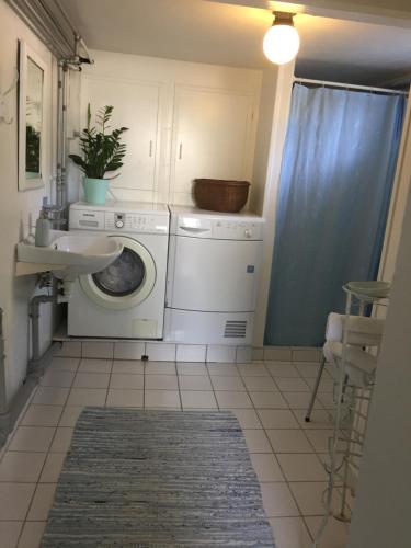 エーベルトフトにあるFerielejligheder i centrum af smukke Ebeltoftのランドリールーム(洗濯機、シンク付)
