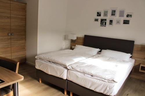 リューデスハイム・アム・ラインにあるホテル ツム ベーレンの小さなベッドルーム(白いシーツ付きのベッド1台付)