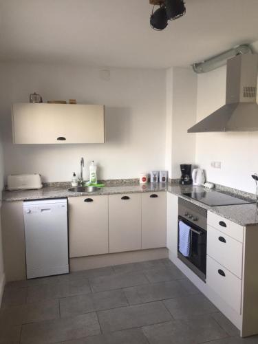 a kitchen with white cabinets and a stove top oven at River Ebro Apartments in Móra d'Ebre