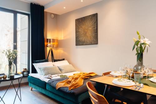ein Wohnzimmer mit einem Bett und einem Esstisch in der Unterkunft Veronese Apartments by LoftAffair in Krakau
