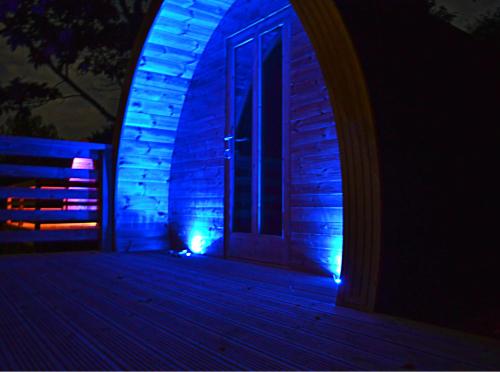 a house with blue lights on the front of it at Craskie Glamping Pods in Inverness