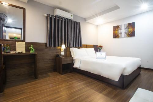 una camera d'albergo con letto e specchio di LEE HOTEL ad Ho Chi Minh