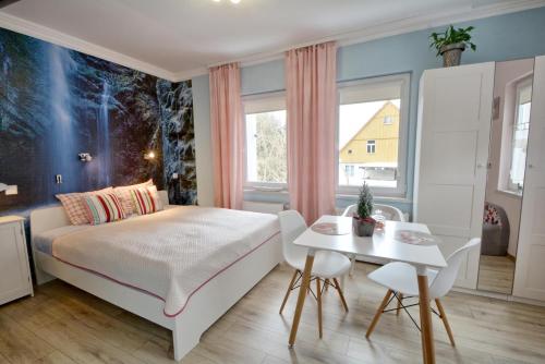 - une chambre avec un lit et une table avec des chaises dans l'établissement Apartament Gałązka Jabłoni, à Duszniki-Zdrój