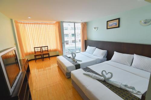 a hotel room with two beds and a window at Cha-Am Fish Star in Cha Am
