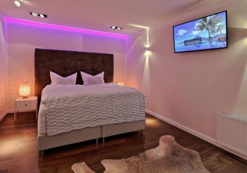 a bedroom with a bed with a tv on the wall at Thiel Apartments in Krefeld