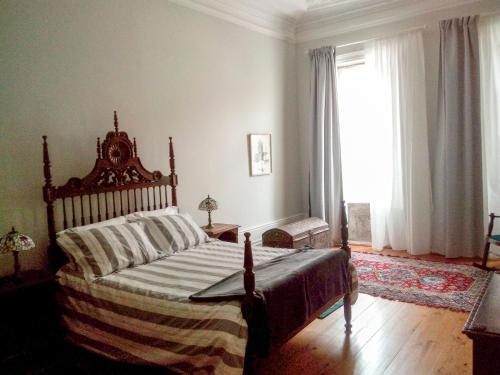 Casa Familiar do Porto في بورتو: غرفة نوم بسرير ونافذة كبيرة