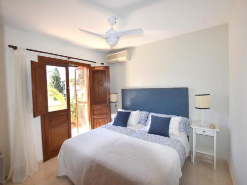 - une chambre avec un lit et un ventilateur de plafond dans l'établissement Casa Arenal, à Jávea