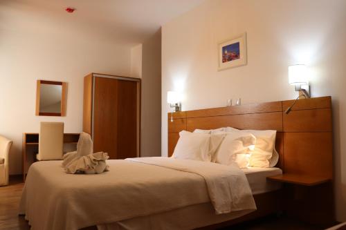 une chambre avec un grand lit avec des oreillers blancs dans l'établissement Hotel Belém Tejo - Setubalense, à Lisbonne