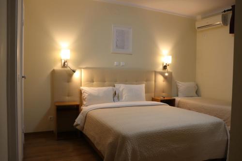 a hotel room with two beds and two lights at Hotel Belém Tejo - Setubalense in Lisbon